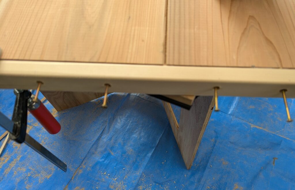 棚板の補強板側面のダボ穴にスリムビスを固定している写真