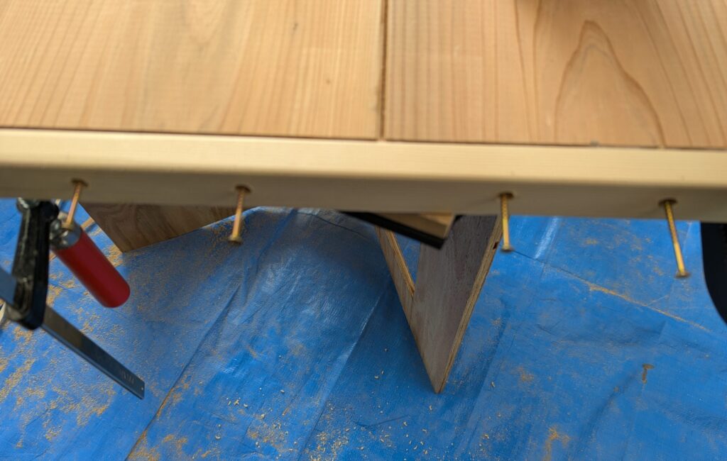 テーブル板のダボ穴にビスを固定している写真