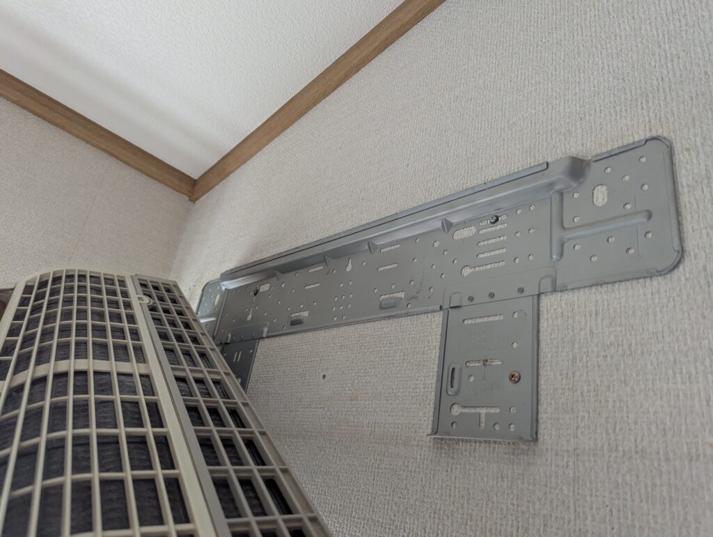 古い室内機を撤去した直後の壁面と旧据付板