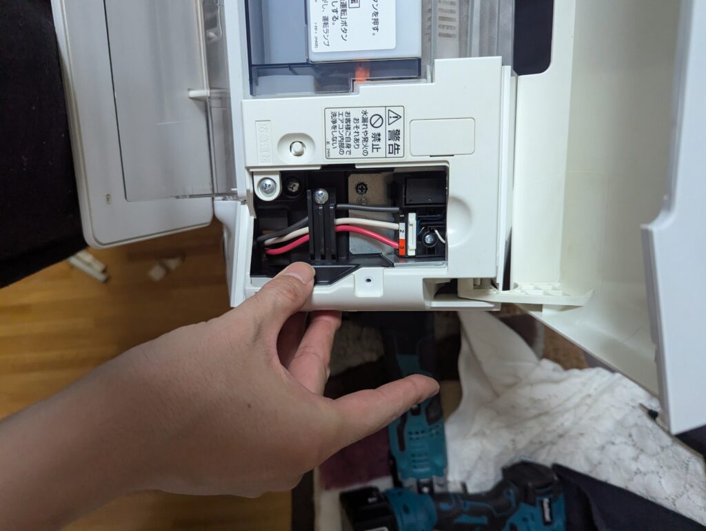 室内機の端子台にVVFケーブルの黒・白・赤を接続しケーブルクランプで固定している様子